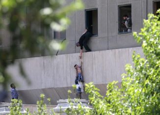 Policías iraníes evacuan a un niño del edificio del parlamento