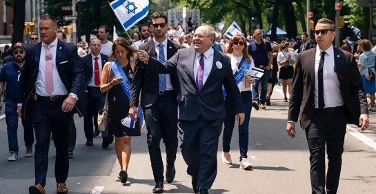 Gente marchando en el medio de la calle, el cónsul de Israel al frente, banderas de Israel, guardaespaldas a los costados