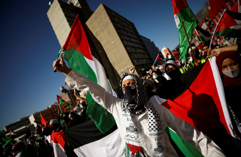 Manifestantes sudafricanos llevan pancartas durante una protesta tras los enfrentamientos entre palestinos y la policía israelí en la mezquita de Al Asqa en Jerusalén, frente al parlamento en Ciudad del Cabo, Sudáfrica, el 11 de mayo de 2021. (Crédito: MIKE HUTCHINGS / REUTERS)